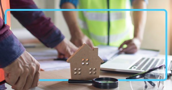 Tradeworkers looking at laptop and paperwork
