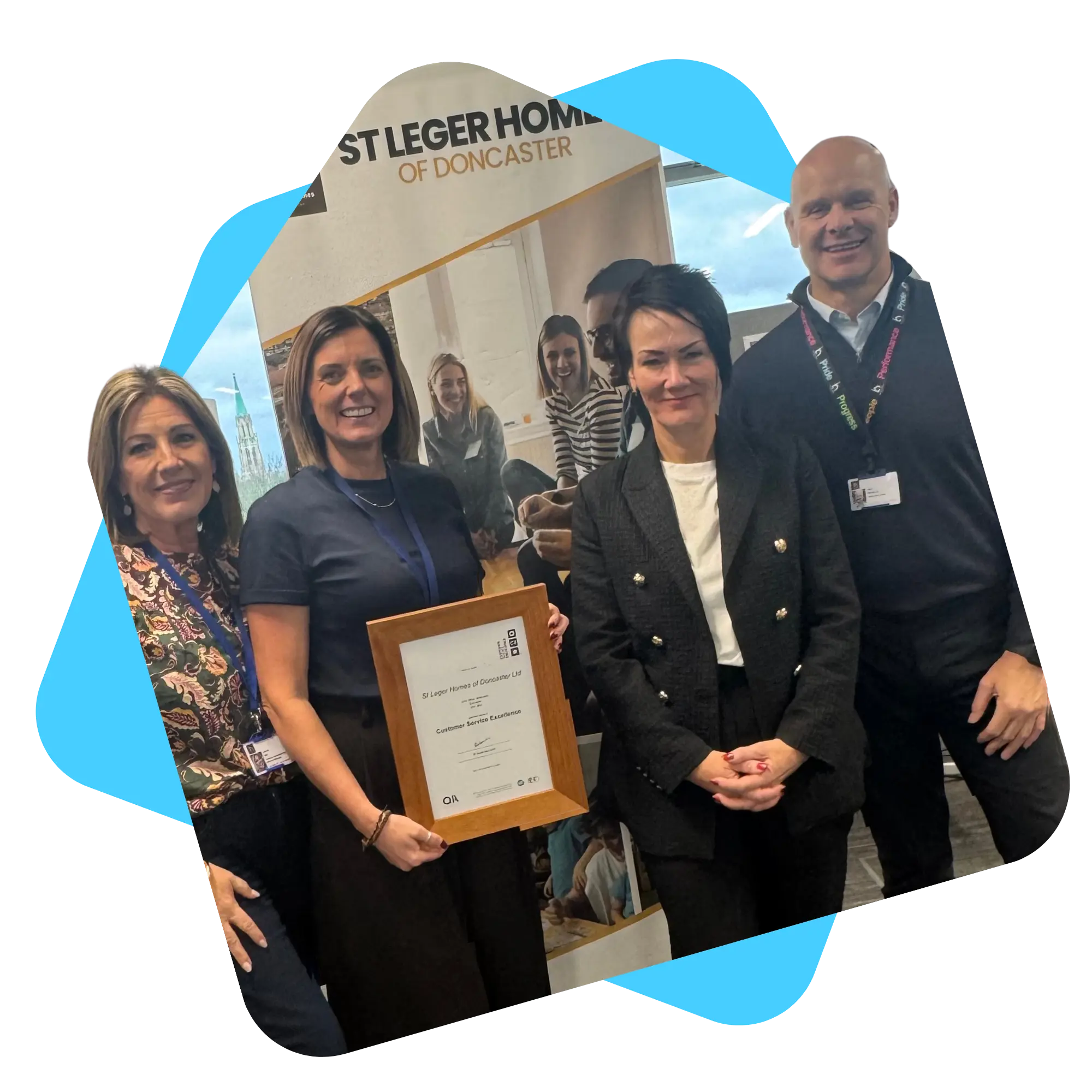 Staff celebrating Customer Excellence Accreditation in house frame