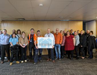 Property Services posing for photograph with Homes board